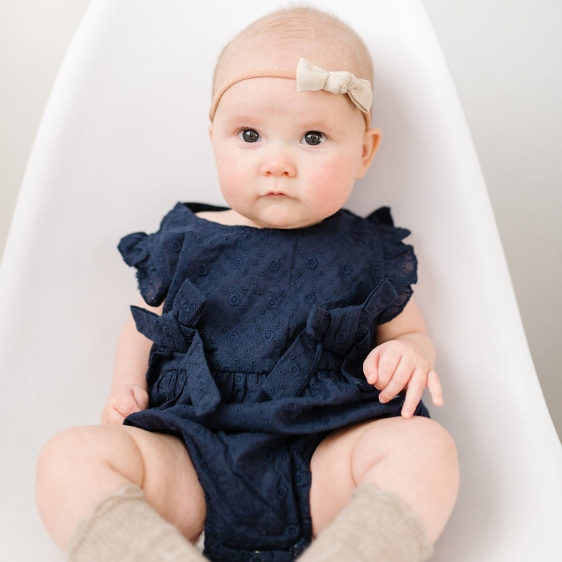 Baby girl wearing our navy blue romper