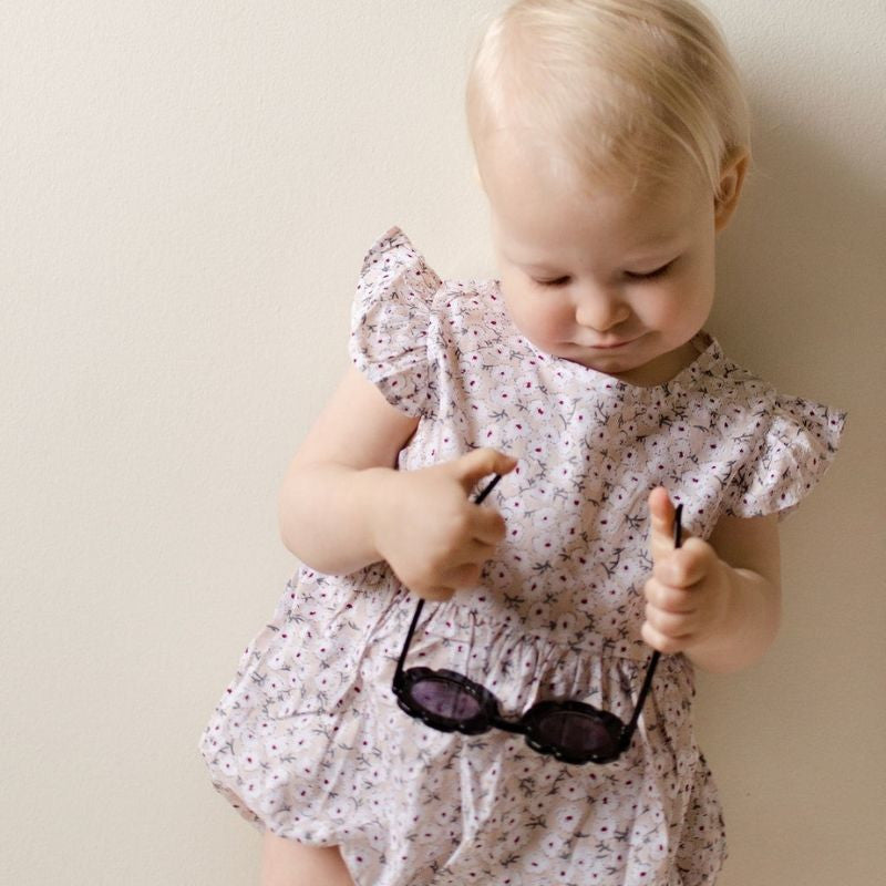 baby girl wearing our  romper with soft floral print all over