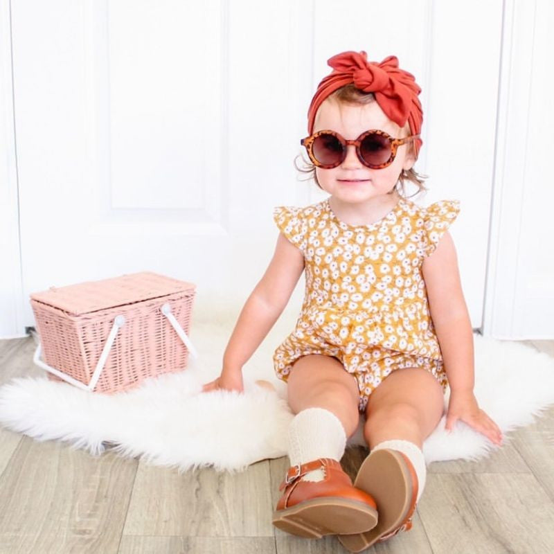 toddler girl wearing our floral romper in mustard